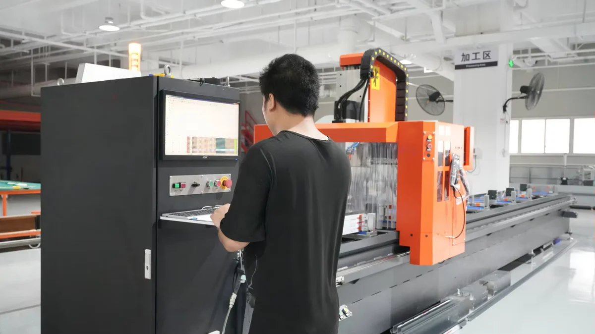 An operator works at the control console of a profile-processing machine.